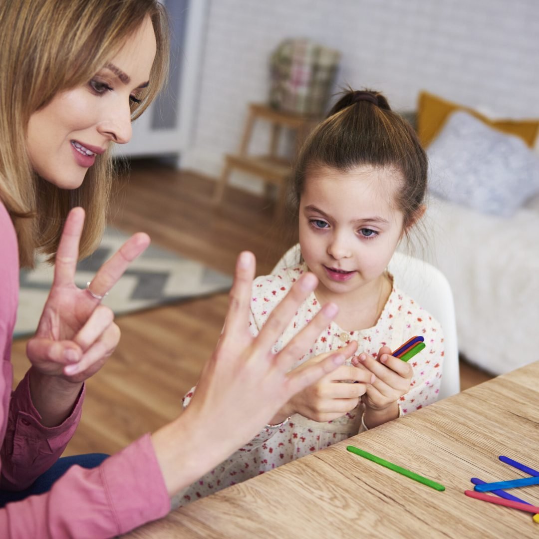 Young mum teaching child to count at home